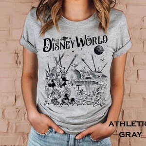 Retro Walt Disney World shirt with vintage-style illustrations of Magic Kingdom, Epcot, Hollywood Studios, and Animal Kingdom featuring classic Disney icons and park landmarks in a nostalgic line-art design.