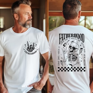 Funny Fatherhood shirt featuring rock and roll skeleton hand with sunglasses and lightning bolts, bold graphic tee for dads who love music, cool retro Father's Day shirt for first-time dad or new dad, punk dad gift t-shirt with skeleton design, Father's Day gift for husband from kids, edgy and fun dad shirt with vintage rock band vibe, fatherhood rocks themed tee for dad’s birthday or family photos