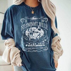 Vintage Steamboat Willie shirt featuring classic black and white Mickey Mouse steering a ship wheel, retro Disney cartoon design, perfect for Magic Kingdom trips, Disney family vacation outfits, or nostalgic Mickey Mouse birthday gifts for adults and kids.