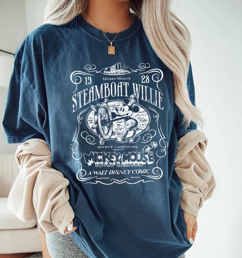 Vintage Steamboat Willie shirt featuring classic black and white Mickey Mouse steering a ship wheel, retro Disney cartoon design, perfect for Magic Kingdom trips, Disney family vacation outfits, or nostalgic Mickey Mouse birthday gifts for adults and kids.