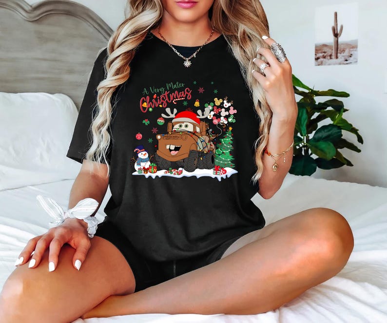Festive Disney Cars holiday shirt with Mater, decorated with Christmas lights and a snowman, ideal Christmas gift for Disney and Cars lovers.
