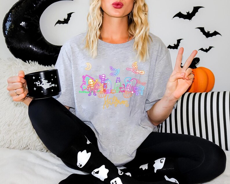 Neon Halloween glow in-the dark tee with eerie skeletons, playful ghosts, and a witch, ideal for Halloween parties or trick-or-treating fun.