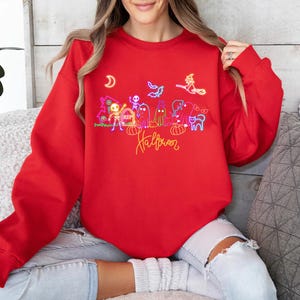 Fun glow in the-dark Halloween shirt with neon skeletons, spooky ghosts, and a witch design, perfect for trick-or-treating and Halloween festivities.