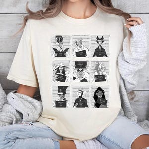 Retro Disney Villains mugshot shirt featuring lineup of Evil Queen, Ursula, Jafar, Scar, Maleficent, Cruella, Captain Hook, Dr. Facilier, and Queen of Hearts, perfect for Halloween, Disney villain fans, and Magic Kingdom group trips.