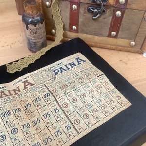 Può includere: Un biglietto della lotteria vintage con le parole "AINA PAINA" stampate su di esso. Il biglietto è datato febbraio 1949 e gennaio 1949. Il biglietto ha una griglia di numeri e lettere.