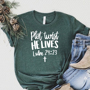 May include: A green t-shirt with the text "Plot twist HE LIVES Luke 24:23" in white lettering and a white cross.