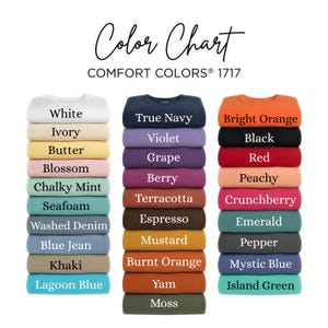 May include: A Comfort Colors 1717 color chart featuring three vertical stacks of folded t-shirts in various shades. The text includes White, Ivory, Butter, Blossom, Chalky Mint, Seafoam, Washed Denim, Blue Jean, Khaki, Lagoon Blue, True Navy, Violet, Grape, Berry, Terracotta, Espresso, Mustard, Burnt Orange, Yam, Moss, Bright Orange, Black, Red, Peachy, Crunchberry, Emerald, Pepper, Mystic Blue, and Island Green.