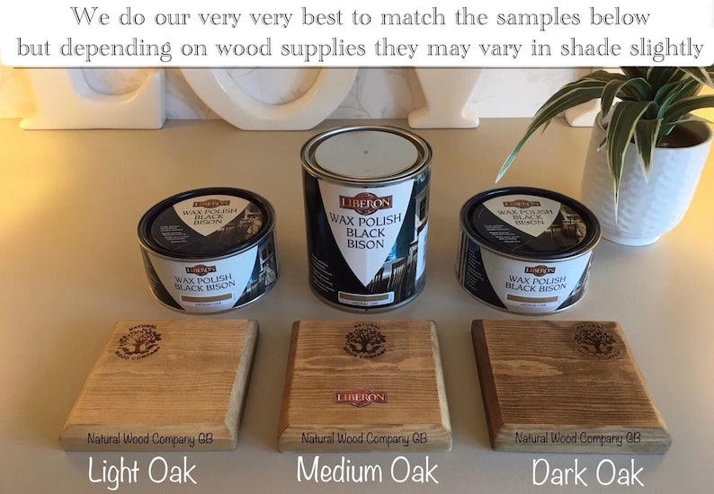Op de afbeelding: Afbeelding met drie eikenhouten stalen in verschillende tinten, van licht tot donker, met blikken Liberon Wax Polish Black Bison. De stalen zijn gelabeld met Licht Eiken, Medium Eiken en Donker Eiken. De tekst op de afbeelding luidt: "We doen ons uiterste best om de onderstaande voorbeelden te matchen, maar afhankelijk van de houtvoorraad kunnen ze enigszins in tint vari&euml;ren."