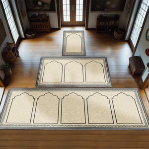 May include: Three beige prayer rugs with black borders and arched designs. The rugs are arranged in a hallway with wooden floors.