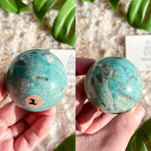 May include: A green and white amazonite sphere with a number "2" sticker on it.