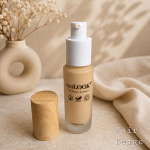 May include: A bottle of "ecolOOK" foundation in "Fair Beige" with a white pump and wooden cap. The bottle is next to a vase with dried flowers and a beige cloth.