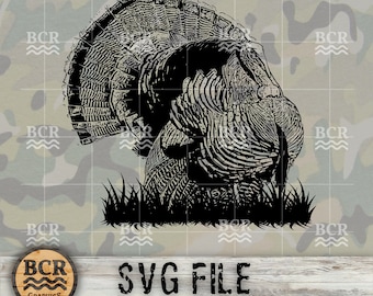 Op de afbeelding: Zwart-witte silhouet van een wilde kalkoen met zijn veren uitgespreid. De kalkoen staat in een grasveld. De afbeelding is op een camouflage achtergrond met de tekst "SVG FILE" onder de kalkoen.