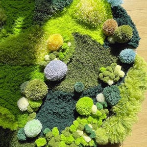 May include: A green, blue and yellow rug made of fluffy yarn. The rug is shaped like a circle and has a variety of textures. The rug is made of different shades of green, blue and yellow yarn. The rug is perfect for adding a touch of whimsy to any room.
