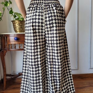 Peut inclure: Pantalon large &agrave; jambes larges &agrave; carreaux noirs et blancs avec une taille &eacute;lastique.