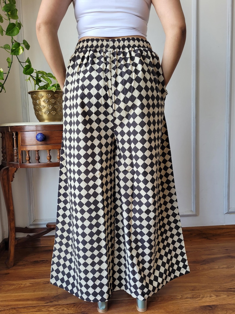 Peut inclure: Pantalon large &agrave; jambes larges &agrave; carreaux noirs et blancs avec une taille &eacute;lastique.