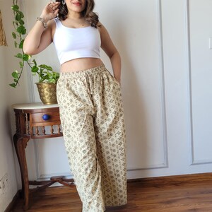 Peut inclure: Pantalon large beige &agrave; imprim&eacute; g&eacute;om&eacute;trique brun. Le pantalon a une taille &eacute;lastique et une coupe ample.