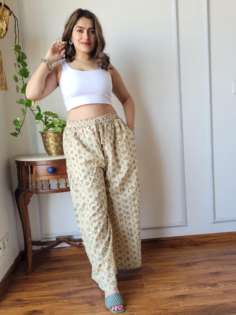 Peut inclure: Pantalon large beige &agrave; imprim&eacute; g&eacute;om&eacute;trique brun. Le pantalon a une taille &eacute;lastique et une coupe ample.