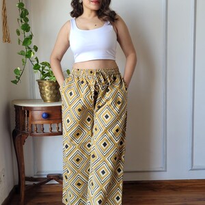 Peut inclure: Un pantalon large &agrave; jambes larges avec un motif g&eacute;om&eacute;trique dans les tons jaune moutarde et noir. Le pantalon a une taille &eacute;lastique et un cordon de serrage.