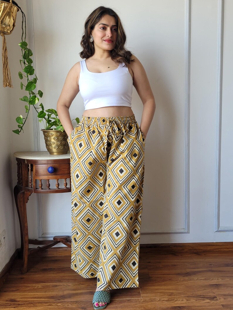 Peut inclure: Un pantalon large &agrave; jambes larges avec un motif g&eacute;om&eacute;trique dans les tons jaune moutarde et noir. Le pantalon a une taille &eacute;lastique et un cordon de serrage.