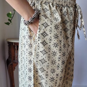 Peut inclure: Un pantalon cr&egrave;me avec un motif g&eacute;om&eacute;trique noir. Le pantalon a une taille &eacute;lastique et un cordon de serrage.