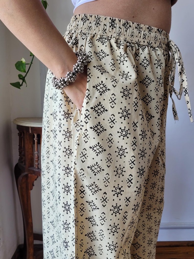 Peut inclure: Un pantalon cr&egrave;me avec un motif g&eacute;om&eacute;trique noir. Le pantalon a une taille &eacute;lastique et un cordon de serrage.