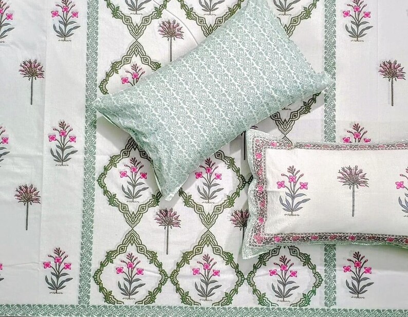 Puede incluir: Juego de cama con estampado floral blanco y verde. El juego incluye una s&aacute;bana encimera, dos fundas de almohada y una s&aacute;bana bajera. El estampado floral presenta flores rosas y hojas verdes. Las fundas de almohada tienen un patr&oacute;n geom&eacute;trico verde.