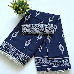 May include: A navy blue cotton saree with a white floral print and white pom-poms along the border. The saree comes with a matching blouse piece.