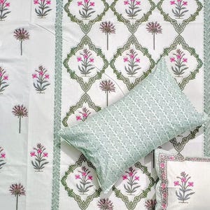 Puede incluir: Juego de cama blanco con estampado floral en rosa y verde. El juego incluye una s&aacute;bana encimera, una funda de almohada con dise&ntilde;o geom&eacute;trico y una funda de almohada m&aacute;s peque&ntilde;a con dise&ntilde;o floral. La ropa de cama tiene un borde decorativo.