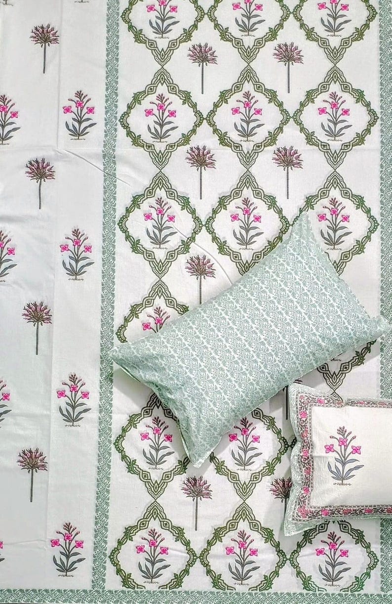 Puede incluir: Juego de cama blanco con estampado floral en rosa y verde. El juego incluye una s&aacute;bana encimera, una funda de almohada con dise&ntilde;o geom&eacute;trico y una funda de almohada m&aacute;s peque&ntilde;a con dise&ntilde;o floral. La ropa de cama tiene un borde decorativo.