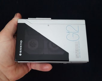May include: A silver and black Sanyo G12 Stereo cassette player with anti-rolling mechanism.