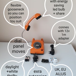 May include: An orange vintage rotary dial desk phone with a flexible gooseneck and a handset. The phone includes an extra extension cable, a daylight LED bulb, and various adapter plugs. The text on the image says "UK, EU, AU, US Please choose."