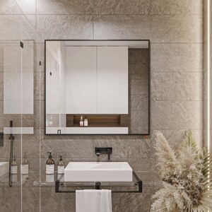 Puede incluir: Un ba&ntilde;o moderno con un lavabo de porcelana blanca, un espejo con marco negro y una cabina de ducha de vidrio. Las paredes est&aacute;n revestidas con azulejos de color marr&oacute;n claro y una toalla blanca cuelga de un toallero negro.