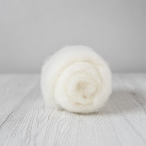May include: A white ball of wool yarn, rolled up and ready for knitting or crocheting.