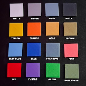 Puede incluir: Una cuadr&iacute;cula de diecis&eacute;is muestras de color cuadradas dispuestas en cuatro filas. Cada muestra est&aacute; etiquetada con su nombre de color correspondiente: blanco, plata, gris, negro, amarillo, naranja, oro, bronce, azul beb&eacute;, azul, azul gris&aacute;ceo, rosa, rojo, morado, verde, verde oscuro.