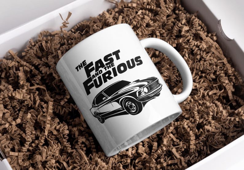 Może przedstawiać: Biały kubek ceramiczny z czarno-białym obrazkiem klasycznego samochodu i tekstem "The Fast and the Furious".