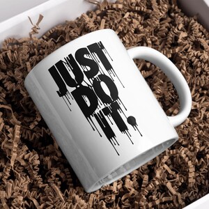 May include: White ceramic mug with a black "JUST DO IT." graphic with dripping paint effect.