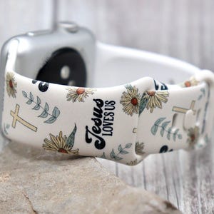 Puede incluir: Banda blanca para Apple Watch con un patrón floral y el texto "Jesús nos ama".