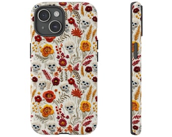 May include: A white phone case with a floral and skull pattern. The flowers are red, orange, and yellow. The skulls are white.