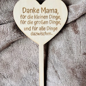 May include: Wooden heart-shaped sign with the text "Danke Mama, f&uuml;r die kleinen Dinge, f&uuml;r die gro&szlig;en Dinge, und f&uuml;r alle Dinge dazwischen."