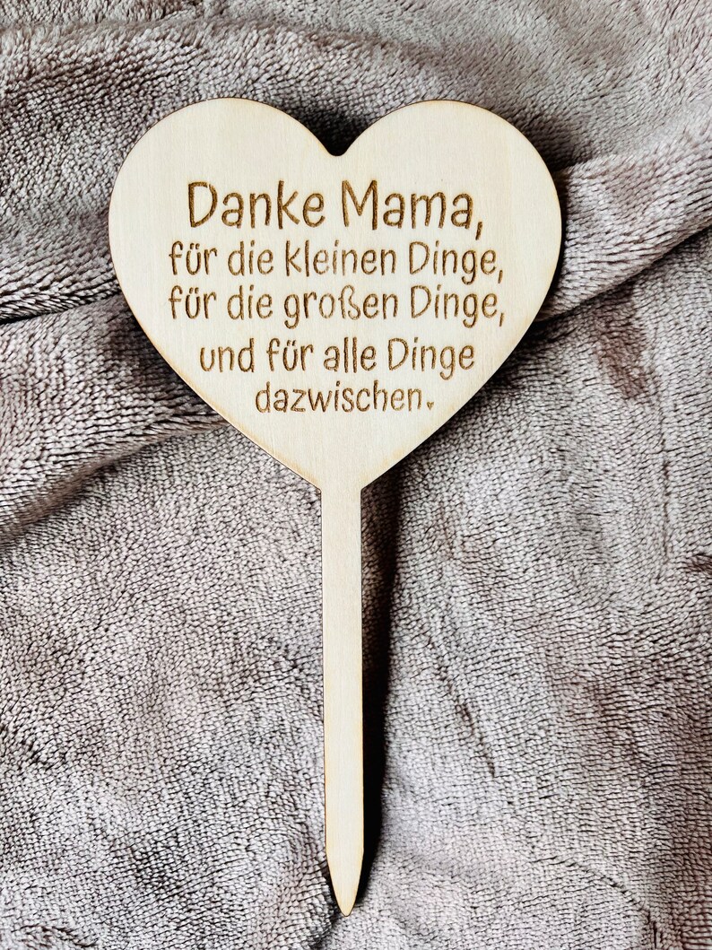 May include: Wooden heart-shaped sign with the text "Danke Mama, f&uuml;r die kleinen Dinge, f&uuml;r die gro&szlig;en Dinge, und f&uuml;r alle Dinge dazwischen."