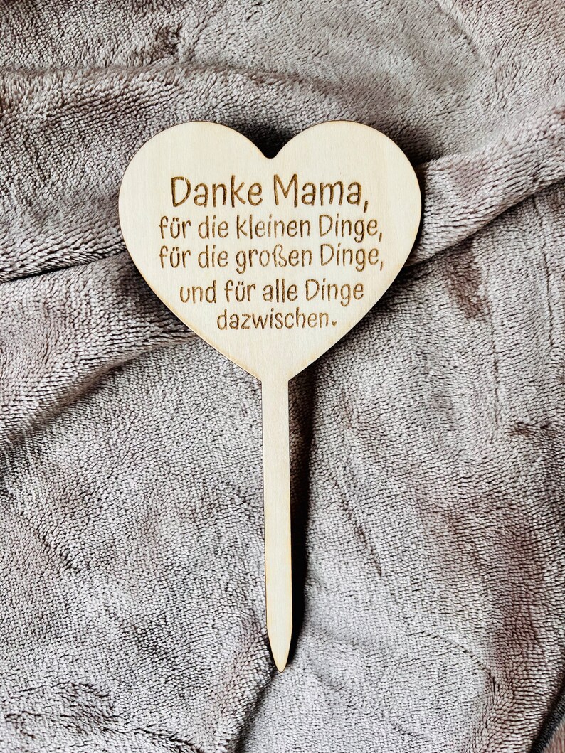 May include: Wooden heart-shaped sign with the text "Danke Mama, f&uuml;r die kleinen Dinge, f&uuml;r die gro&szlig;en Dinge, und f&uuml;r alle Dinge dazwischen."