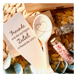 May include: Wooden spoon with a heart carved into it and a wooden spatula with the text "Friends are the most important ingredient in the recipe of life".
