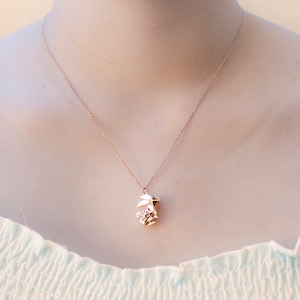 May include: A delicate gold necklace featuring a geometric origami rabbit pendant.
