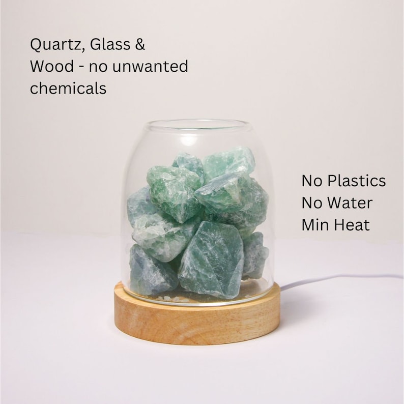 K&ouml;nnte beinhalten: Eine Glasglocke mit einem Holzsockel, die gr&uuml;ne Fluoritkristalle enth&auml;lt. Der Text "No Plastics No Water Min Heat" ist auf der rechten Seite des Bildes sichtbar. Der Text "Quartz, Glass & Wood - no unwanted chemicals" ist oben im Bild sichtbar.