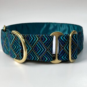 Pu&ograve; includere: Un collare per cani blu turchese con un motivo geometrico e accessori dorati.