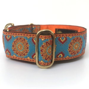 May include: A blue and orange dog collar with a floral pattern and a brass buckle.