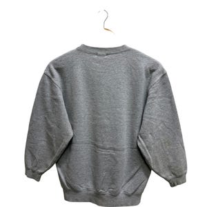 May include: A heather gray sweatshirt with a crew neck and long sleeves, hanging on a white hanger. The back of the sweatshirt is visible, showcasing its simple, classic design. The fabric appears soft and comfortable.
