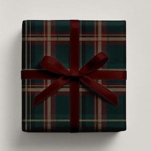 May include: A wrapped gift with a dark green and red plaid pattern. A burgundy ribbon is tied around the gift in a bow. The wrapping paper has a classic tartan design, perfect for the holiday season or special occasions.