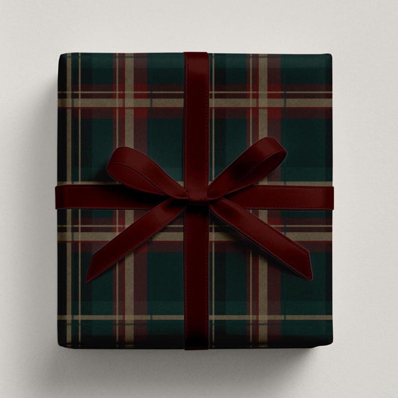 May include: A wrapped gift with a dark green and red plaid pattern. A burgundy ribbon is tied around the gift in a bow. The wrapping paper has a classic tartan design, perfect for the holiday season or special occasions.