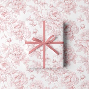May include: A wrapped gift with a pink ribbon on a white background. The wrapping paper features a repeating pattern of pink peony flowers and leaves. The ribbon is tied in a bow.